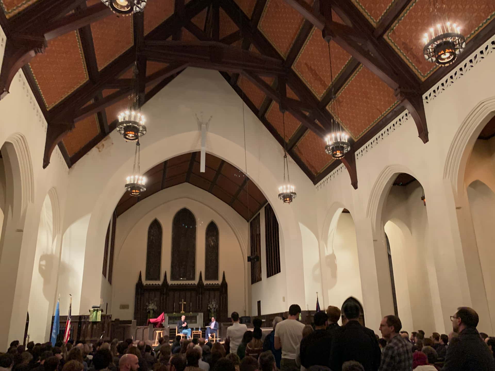 Ezra Klein and Zaki Hamid take audience questions at the front of a crowded church