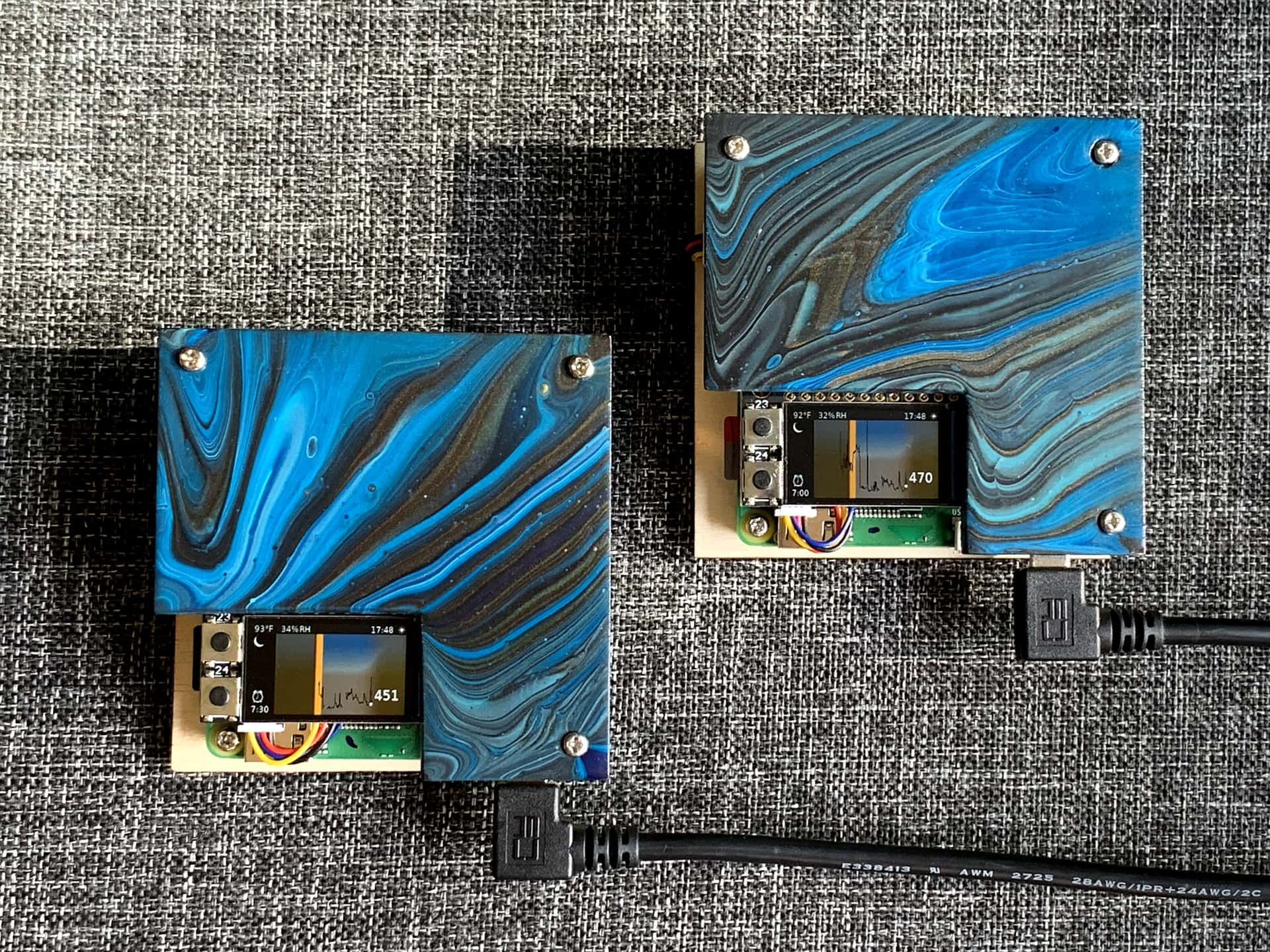 a pair of graphing carbon dioxide monitors built from Raspberry Pis with poured paint wooden cases