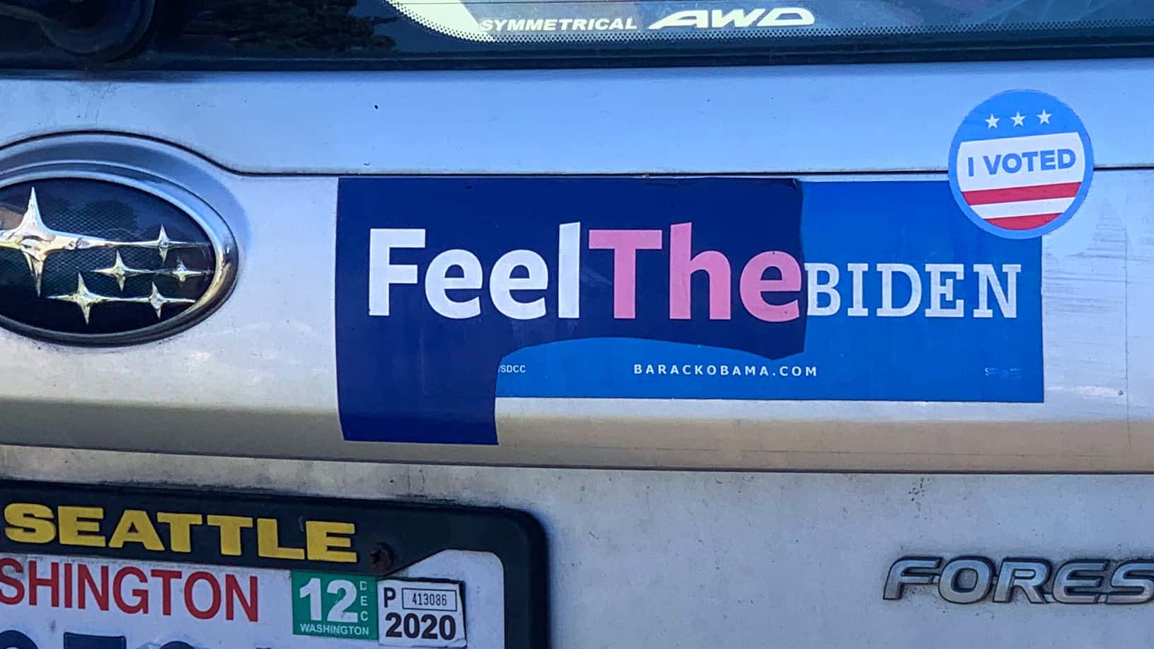 Bernie Sanders 2020 bumper sticker partially torn off to reveal an Obama/Biden 2012 sticker, together reading “Feel The Biden”