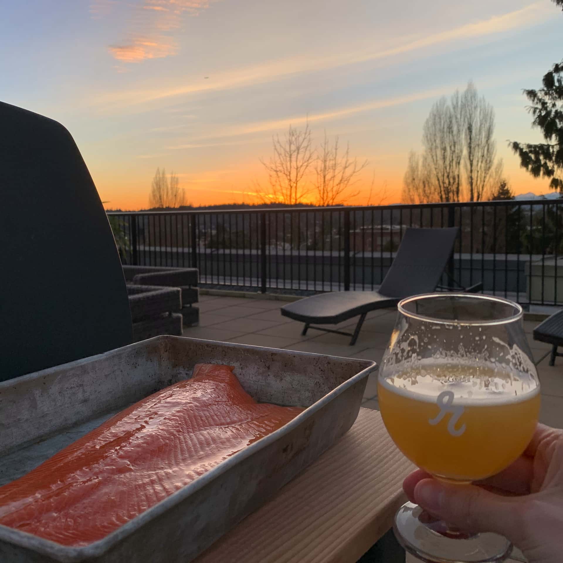 raw fillet of steelhead trout and Reuben’s Brews Double Crush Hazy IIPA next to a grill