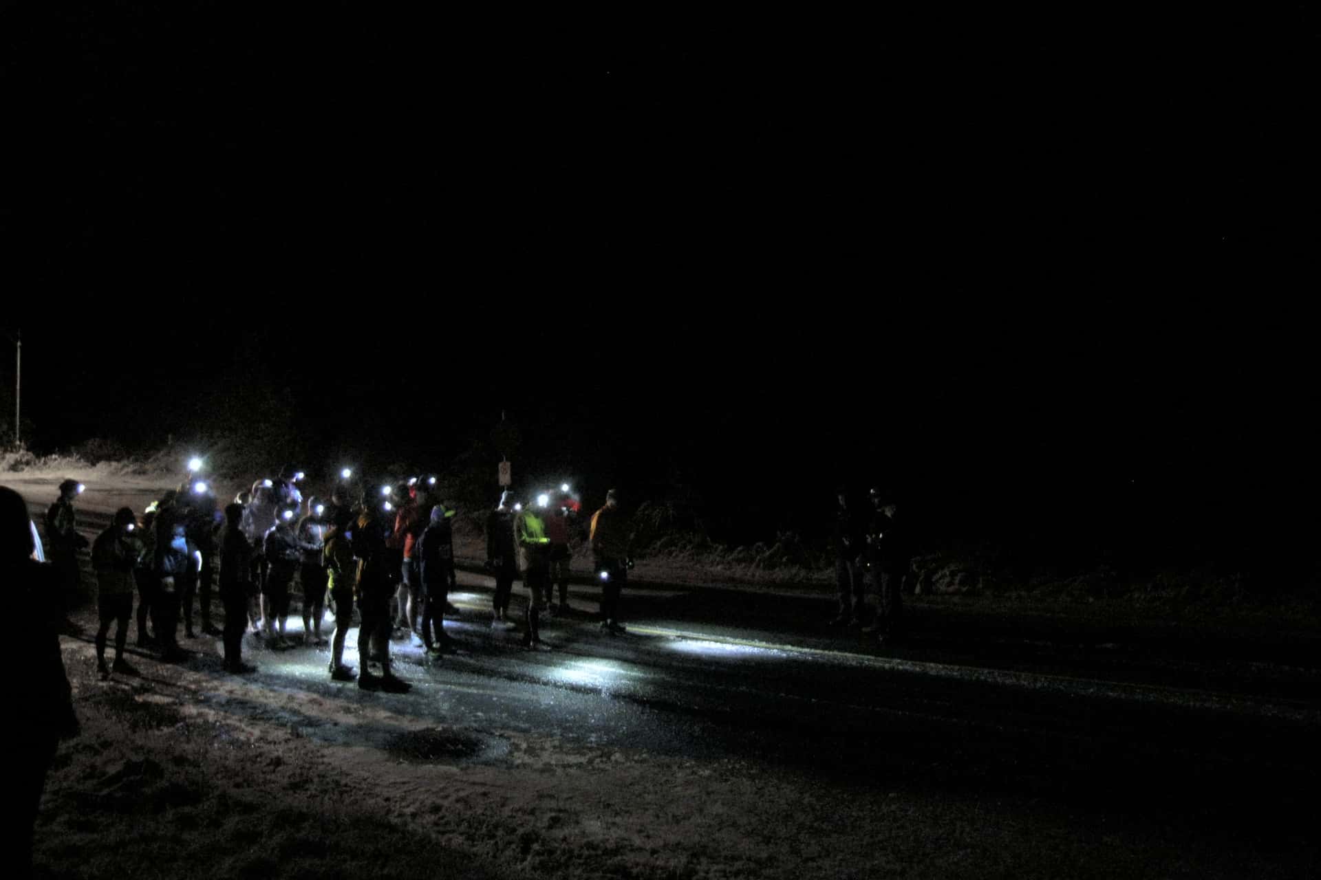 runners wearing head lamps at the starting line of the Whistler 50