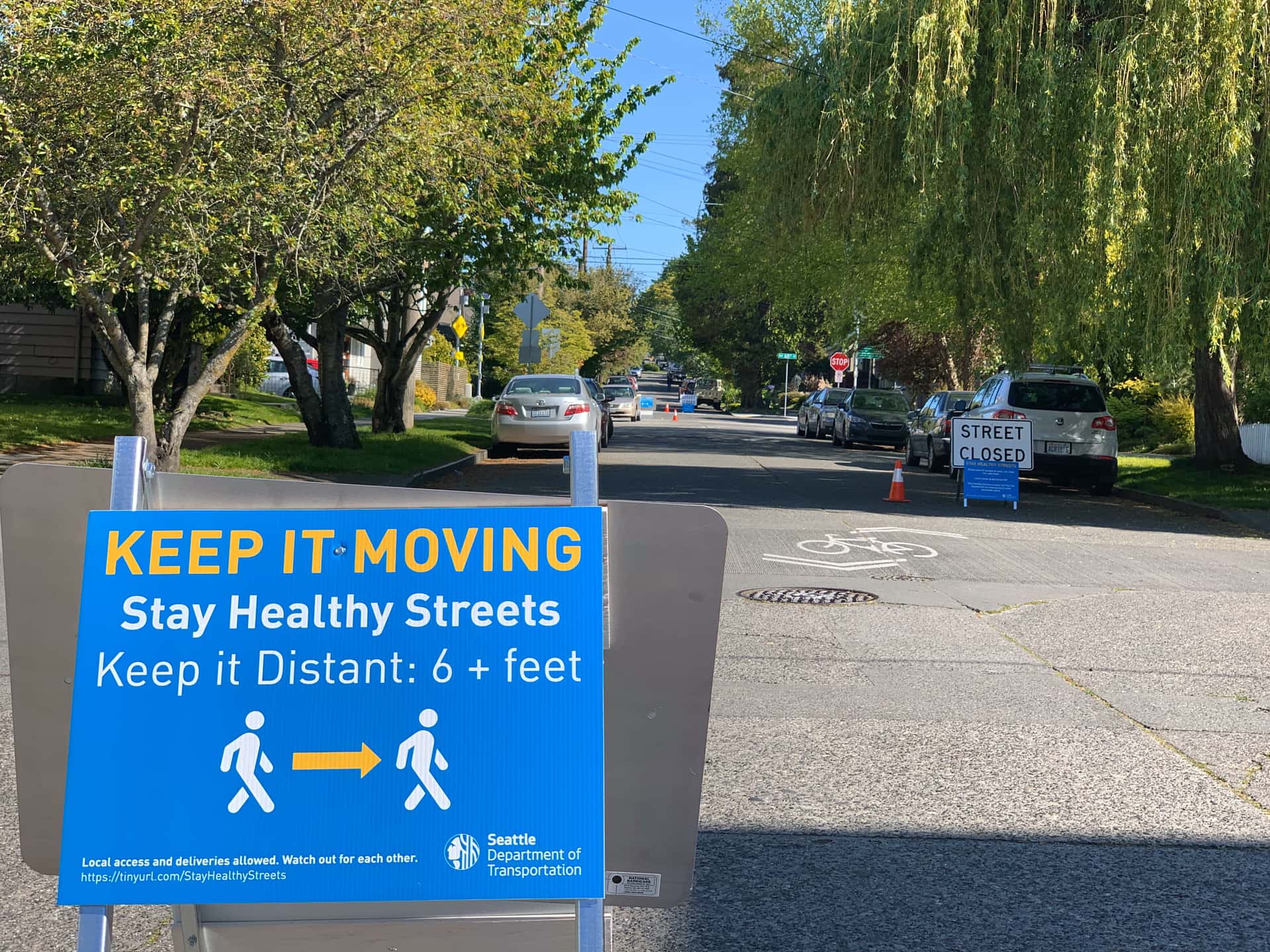 “Stay Healthy” street signage reading “Street Closed” and “Keep it Moving; Stay Healthy Streets; Keep it Distant: 6+ feet”