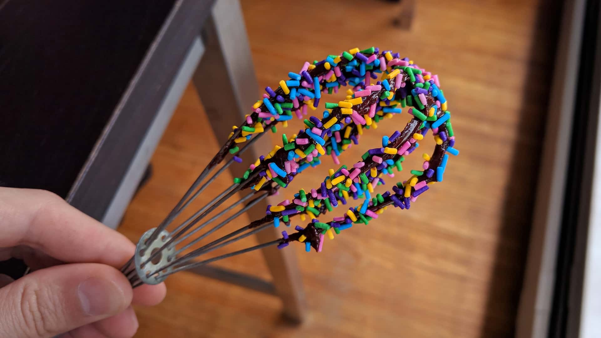 brownie batter–covered whisk coated in colored sprinkles