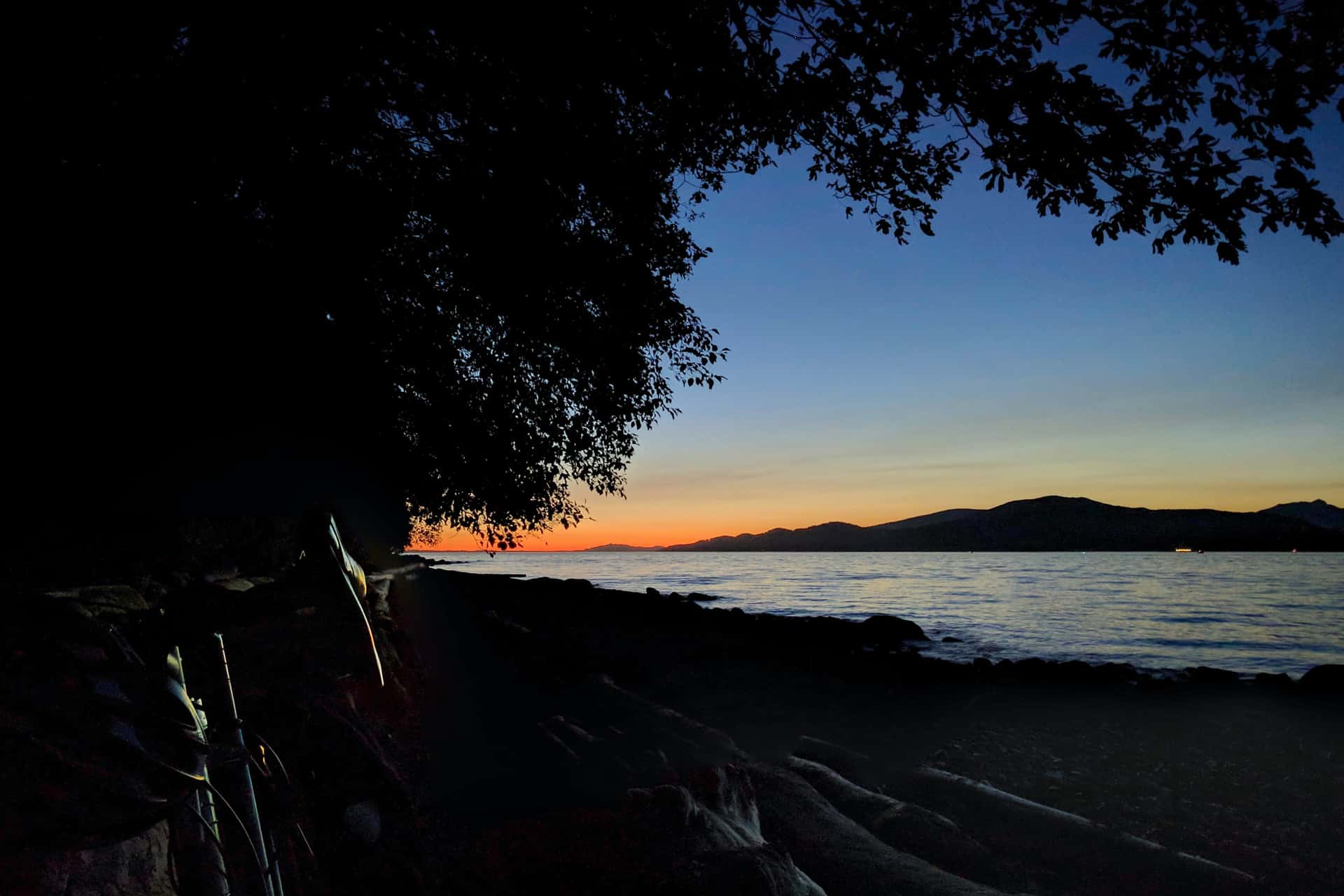 bicycle resting on driftwood at Spanish Banks Beach at sunset