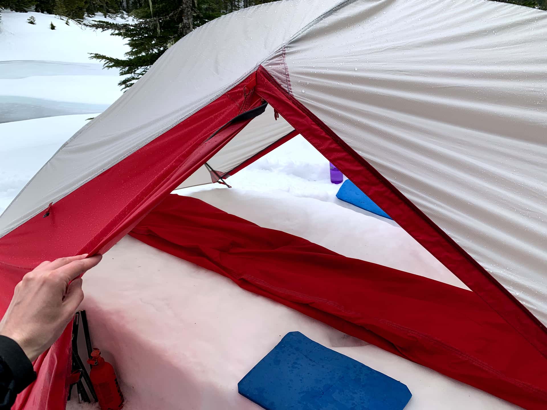 folding a tent body under cover of the erect fly in the rain